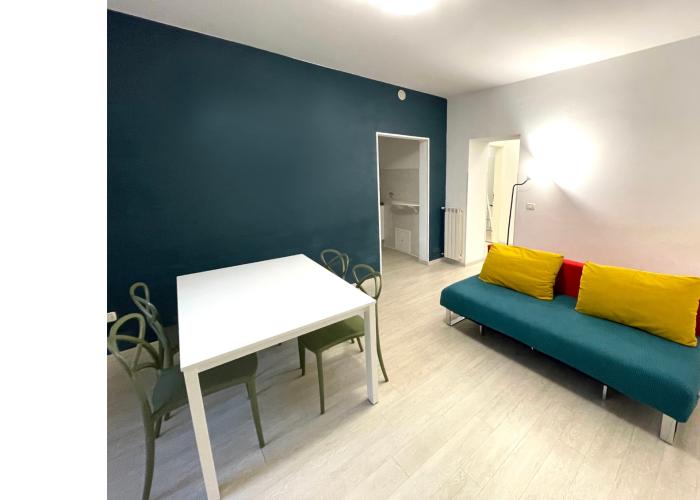 Soggiorno moderno con divano colorato e parete blu.